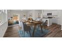 Open-concept living and dining area with wood floors and a sliding glass door to the outside at 7369 Pilatus Ave, Spring Hope, NC 27882