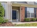 Close up of the front door showing brick accents, and manicured landscaping at 9510 Dellbrook Ct, Raleigh, NC 27617
