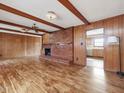 Inviting living room boasting a brick fireplace, wood paneling, wood beams and hardwood floors at 9550 Silk Hope Liberty Rd, Siler City, NC 27344