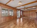 Bright living room featuring wood paneling, wood beams, hardwood floors and plenty of natural light at 9550 Silk Hope Liberty Rd, Siler City, NC 27344