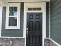 Elegant front door with sidelight and stone accents, showcasing the home's curb appeal at 116 Willow Cameron Way, Angier, NC 27501