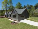 New craftsman-style home with gray siding, stone accents, two-car garage, and a landscaped yard at 15 Rose Garden Dr, Franklinton, NC 27525