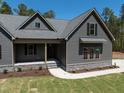 Craftsman-style home with gray siding, stone accents, and a walkway leading to the front door at 15 Rose Garden Dr, Franklinton, NC 27525