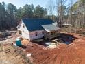 A detailed view of the exterior elevation of the home during construction, showing the porch and surrounding yard at 15 Rose Garden Dr, Franklinton, NC 27525