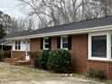 A close up view of the brick ranch house, with partial landscaping and a white front door at 1600 Buffaloe Rd, Garner, NC 27529