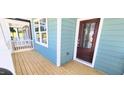 Inviting front porch featuring wood flooring, a modern door, and natural lighting at 1905 Plott Balsam Dr, Wendell, NC 27591
