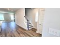 Open-concept living area with wood floors and staircase access at 1905 Plott Balsam Dr, Wendell, NC 27591