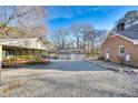 Large gravel parking area featuring a three-car garage and an open carport at 201 Lake St, Fuquay Varina, NC 27526