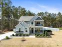 Beautiful two-story home with gray siding, stone accents, and welcoming front porch and balcony at 220 Green Haven Blvd, Youngsville, NC 27596