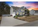 Two-story home with gray siding, stone accents, covered porch, balcony, and a spacious driveway at 220 Green Haven Blvd, Youngsville, NC 27596