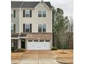Three-story townhome features a two-car garage and a combination of brick and siding at 240 Amber Acorn Ave, Raleigh, NC 27603