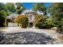 Elegant home with a circular turret, balcony, brick driveway, mature trees, and landscaping at 2658 Davis St, Raleigh, NC 27608