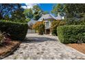 Elegant home with a circular turret, a balcony, and a brick driveway lined with lush greenery at 2658 Davis St, Raleigh, NC 27608