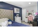 Well-lit bedroom featuring a tufted headboard, vanity, and gray walls, creating a peaceful retreat at 2728 Old Milburnie Rd Rd, Raleigh, NC 27604