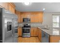 Well-lit kitchen with stainless steel appliances, granite countertops, and hardwood floors at 276 Sagamore Dr, Louisburg, NC 27549