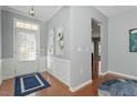 Bright foyer featuring hardwood floors, elegant trim work, and a view into the spacious living area at 314 Fenmore Pl, Cary, NC 27519