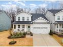 Charming two-story home with white siding, a covered porch, and a two-car garage, creating a welcoming curb appeal at 349 Shadow Falls Dr, Wendell, NC 27591