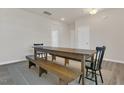 Spacious dining room featuring a wooden table with bench seating and hardwood floors at 3512 Dragonfly River Ct, Raleigh, NC 27604