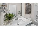 Bright bathroom featuring a white vanity, quartz countertop, decorative mirror, and a plant for flair at 369 Swift Creek Farm Ln, Clayton, NC 27520