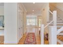Welcoming entryway features hardwood floors, a staircase with metal railing and a view of a bright dining area at 415 Westbury Dr, Chapel Hill, NC 27516