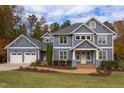 Charming two-story home boasts a manicured lawn, landscaped garden beds, brick walkway and attached two car garage at 415 Westbury Dr, Chapel Hill, NC 27516