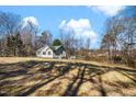 Expansive backyard showcasing the home's exterior, surrounded by mature trees and a clear sky at 421 Danielle Dr, Garner, NC 27529