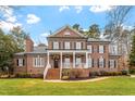 Elegant brick home featuring a classic design, manicured lawn, and inviting front porch with stairs at 5301 Mandrake Ct, Raleigh, NC 27613