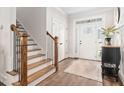 Bright foyer with hardwood floors, staircase, and a stylish entry door at 564 Woodbridge Ct, Wake Forest, NC 27587