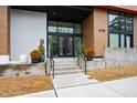 Modern apartment building entrance featuring glass doors, a stone walkway, and landscaped planters at 615 Daniels St # 318, Raleigh, NC 27605