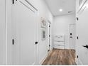 Bright hallway with white walls, wood-look flooring, and several closed doors, plus a white storage cabinet at 615 Daniels St # 318, Raleigh, NC 27605
