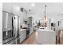 Modern kitchen with stainless steel appliances, gray cabinets, and a white quartz countertop island with pendant lights at 615 Daniels St # 318, Raleigh, NC 27605