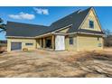 Exterior view of a yellow house with a garage and sliding glass doors to the covered patio at 6509 Zebulon Rd, Wake Forest, NC 27587