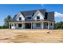 A beautiful two-story home featuring a classic design with a striking roofline and expansive front yard at 6509 Zebulon Rd, Wake Forest, NC 27587
