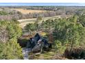 Gorgeous aerial view of a large home with mature trees and a golf course at 7220 Hasentree Way, Wake Forest, NC 27587