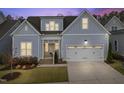 Charming home showcasing light blue siding, a two-car garage, and a well-manicured lawn at 729 Daniel Ridge Rd, Wendell, NC 27591