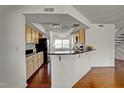 Open kitchen with dark countertops, light wood cabinets and hardwood floors at 7712 Falcon Rest Cir, Raleigh, NC 27615