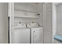 Convenient laundry area with washer, dryer, and shelving for storage at 7712 Falcon Rest Cir, Raleigh, NC 27615