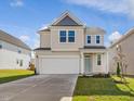 Attractive two-story home with a two-car garage, neutral siding, and a well-maintained front lawn at 89 Willow Cameron Way, Angier, NC 27501