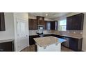 Modern kitchen with dark wood cabinets, stainless steel appliances, and an island at 937 Emmer St, Rolesville, NC 27571