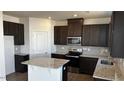 Modern kitchen features granite countertops, stainless steel appliances, and dark wood cabinets at 937 Emmer St, Rolesville, NC 27571