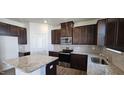 Well-lit kitchen featuring dark cabinetry, granite countertops and stainless steel appliances at 937 Emmer St, Rolesville, NC 27571