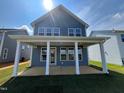 Backyard of home featuring a covered porch with stately pillars and a large grassy yard at 98 Willow Cameron Way, Angier, NC 27501