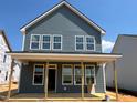 Two-story home with light blue siding with large windows under construction at 98 Willow Cameron Way, Angier, NC 27501