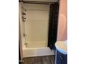 Classic white tub and shower combination with a dark shower curtain, and a stylish white vanity at 1204 Avondale Dr, Burlington, NC 27217