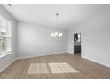 Bright dining room with hardwood floors, modern chandelier, and large window for natural light at 15 Nimble Way # 175, Clayton, NC 27520