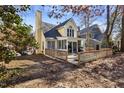 Back exterior of charming home featuring a spacious wooden deck and screened in porch at 1721 Kingston Heath Way, Raleigh, NC 27604