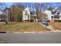 Charming yellow home with mature trees, adjacent to a shared driveway and neighbor's homes at 1721 Kingston Heath Way, Raleigh, NC 27604