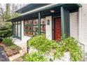Inviting front porch with decorative foliage, a wood door, and brickwork details, providing a welcoming entrance at 1824 S Lakeshore Dr, Chapel Hill, NC 27514