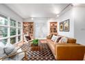 Cozy living room featuring modern furniture, hardwood floors, built-in bookshelves, and ample natural light at 1824 S Lakeshore Dr, Chapel Hill, NC 27514