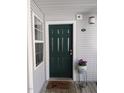 Inviting front door with decorative potted flowers and gray siding at 1911 Wolftech Ln # 304, Raleigh, NC 27603